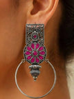 Single oxidised silver floral hoop earring worn on a woman's ear showing scale and drape