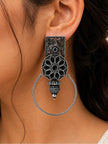 Close-up side view of one oxidised silver floral hoop earring worn on a woman's ear showing full drop length