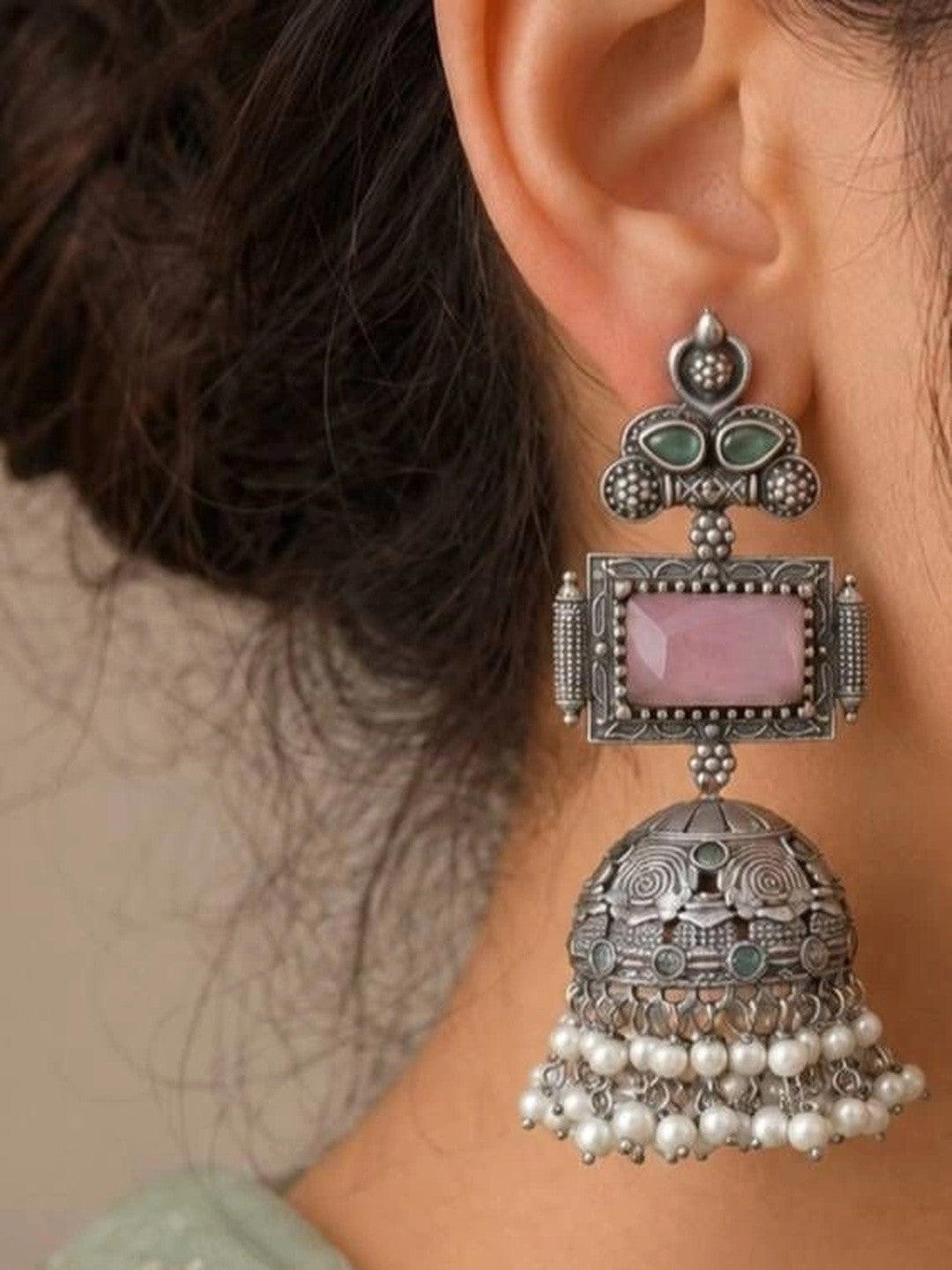 Oxidised silver jhumka earring worn on a woman's ear showing full length and pearl drops