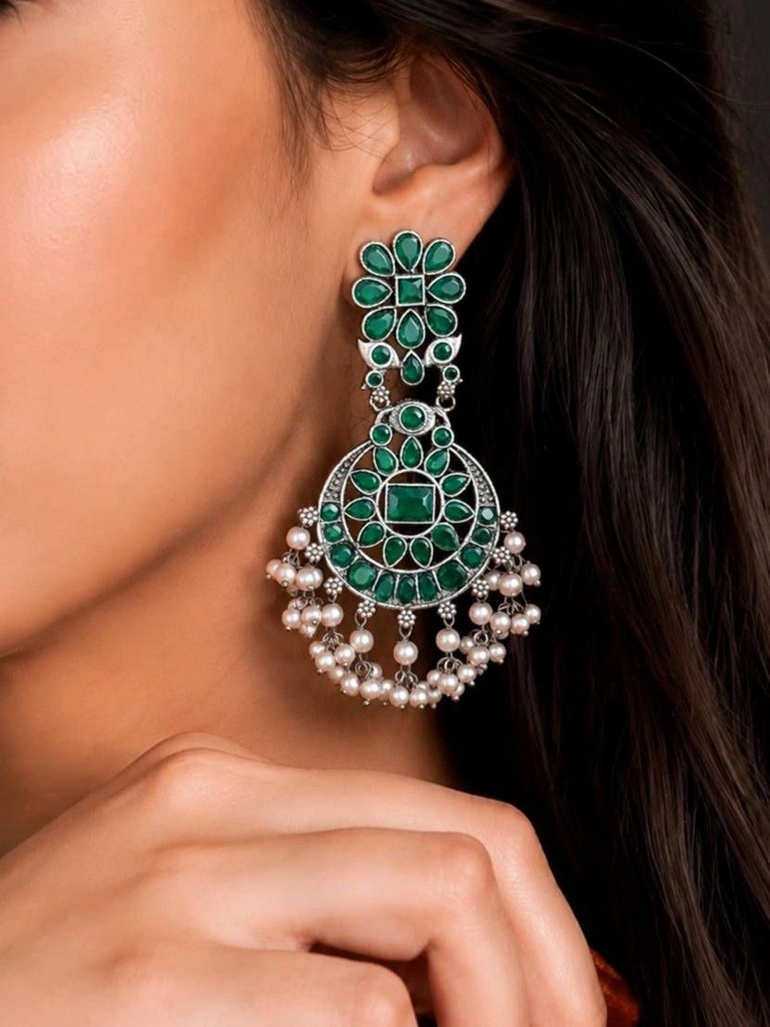 Woman wearing large oxidised silver chandbali earring with green stones and ivory pearl drops