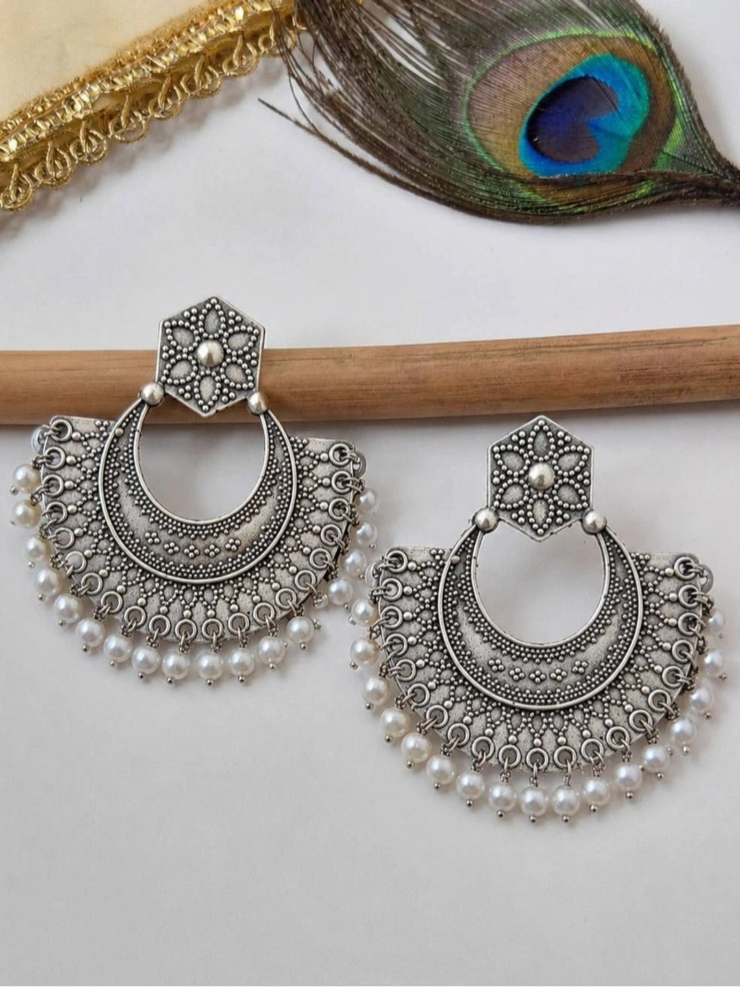Front view of oxidised silver chandbali earrings showing dotwork detail and white pearl bead fringe