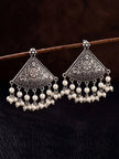 Pair of oxidised silver fan-shaped earrings with white pearl bead drops hanging from a wooden rod