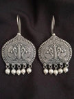 Pair of oxidised silver peacock engraved drop earrings with five white pearl dangles on black background