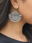 Oxidised silver peacock chandbali earring worn on woman's ear showing scale and drape against dark hair