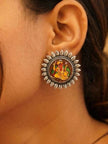 Ganesha printed silver stud earring worn on a woman's ear against a natural skin backdrop