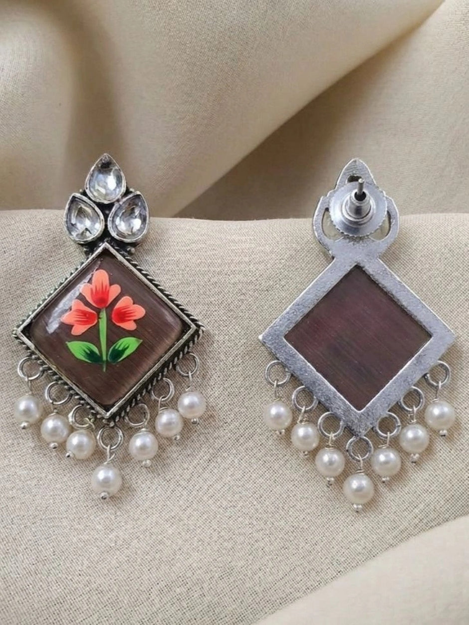 Front and back view of oxidised silver meenakari earrings showing stud post and plain reverse side