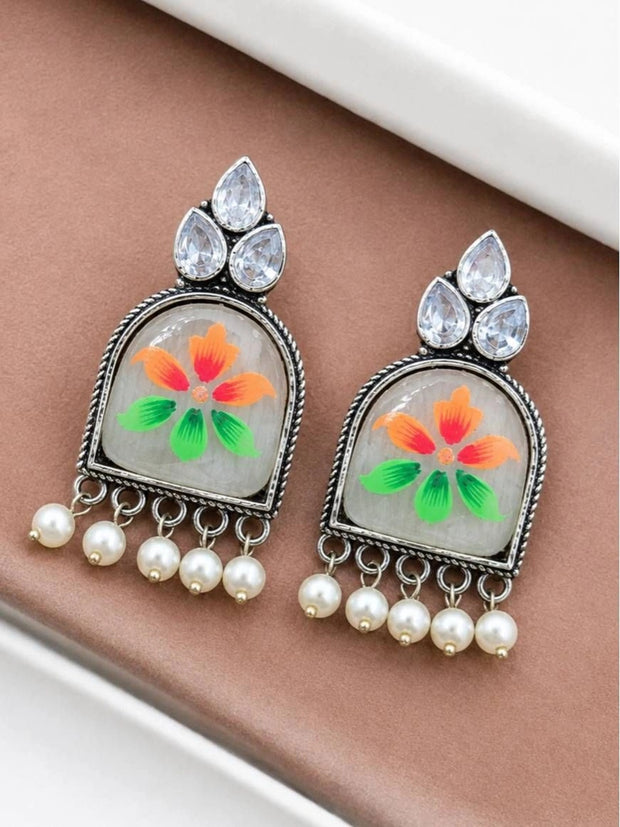 Both meenakari chandbali earrings laid flat showing crystal stone cluster and five pearl drop dangles