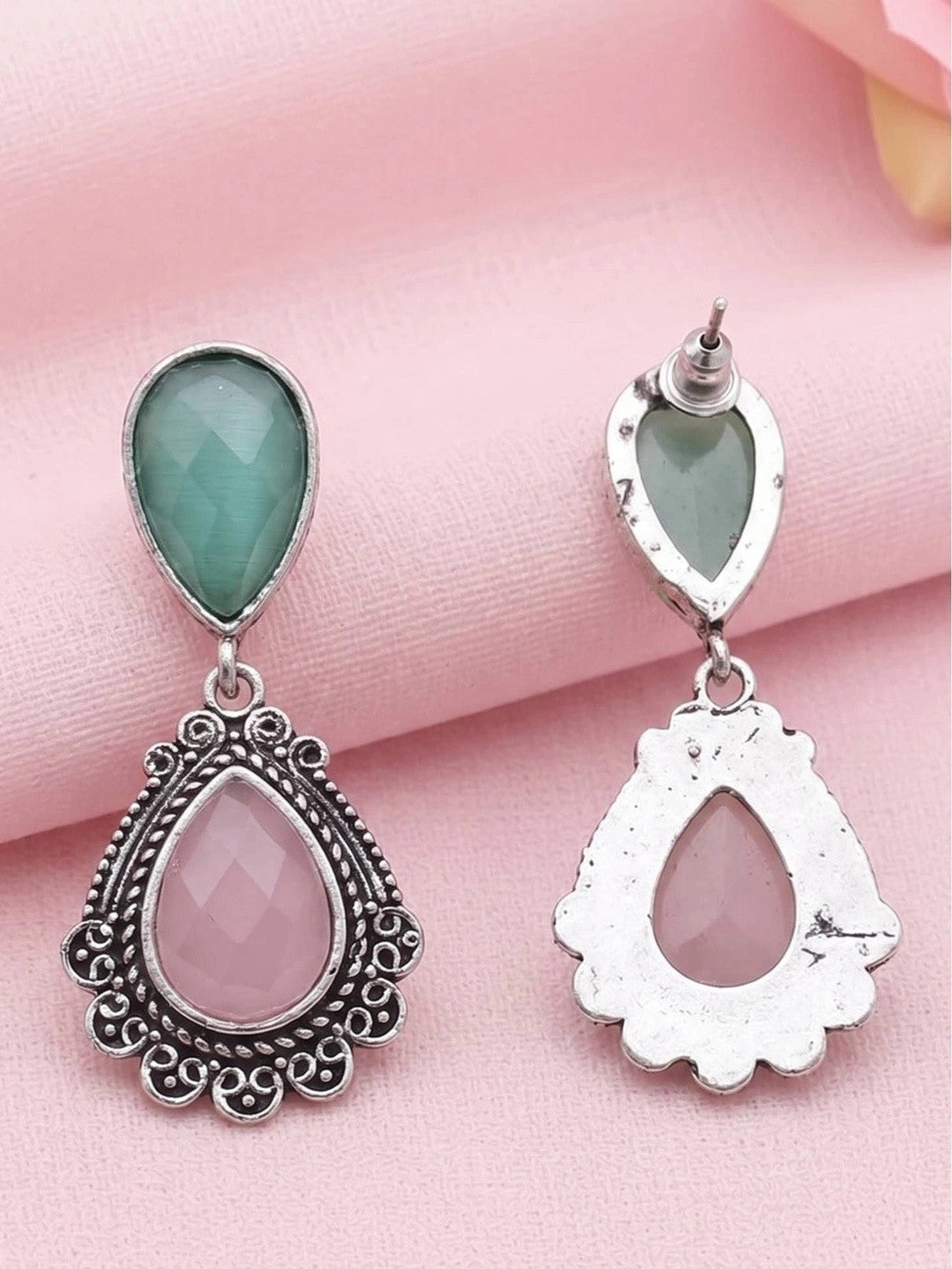 Front and back view of oxidised silver teardrop earrings on pink fabric showing push-back stud