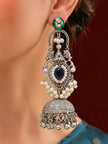 Woman wearing long oxidised silver chandbali jhumka earring with pearl clusters and green kundan stud top