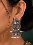Oxidised silver chandbali earring worn on ear, showing floret top, engraved oval body and pearl drop fringe