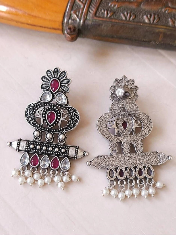 Front and back of oxidised silver chandbali earring pair laid flat on white surface