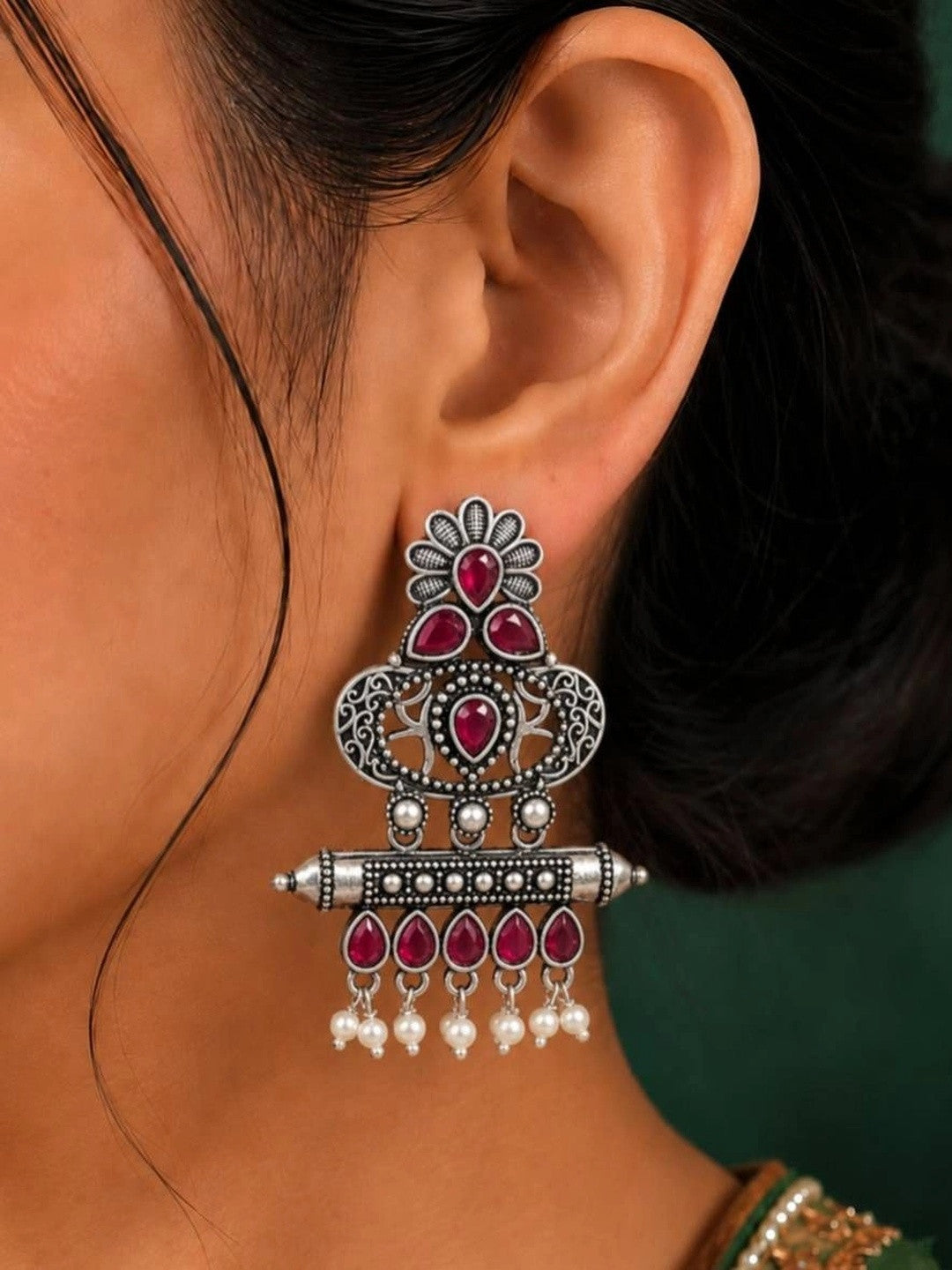 Oxidised silver chandbali earring with ruby red stones and pearl drops worn on ear