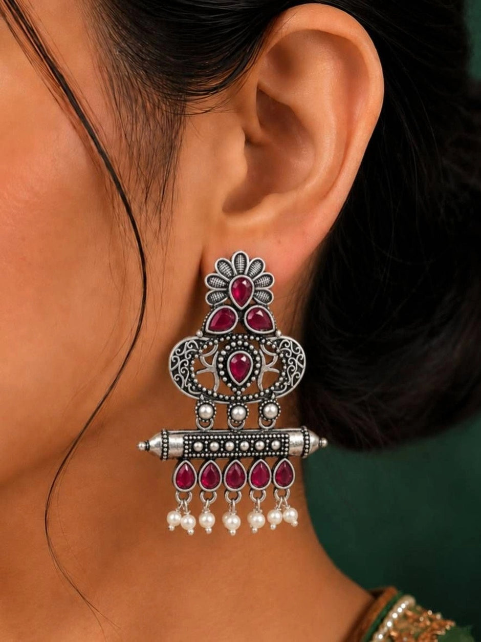 Oxidised silver chandbali earring with ruby red stones and pearl drops worn on ear