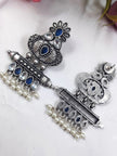 Front and back view of oxidised silver chandbali earrings laid flat on white surface