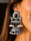 Oxidised silver jhumka earring worn on ear showing teal stone stud, pearl drops and engraved dome with ghungroo bells