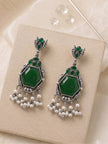 Pair of oxidised silver chandbali earrings with green stones and white pearl fringe on cream box