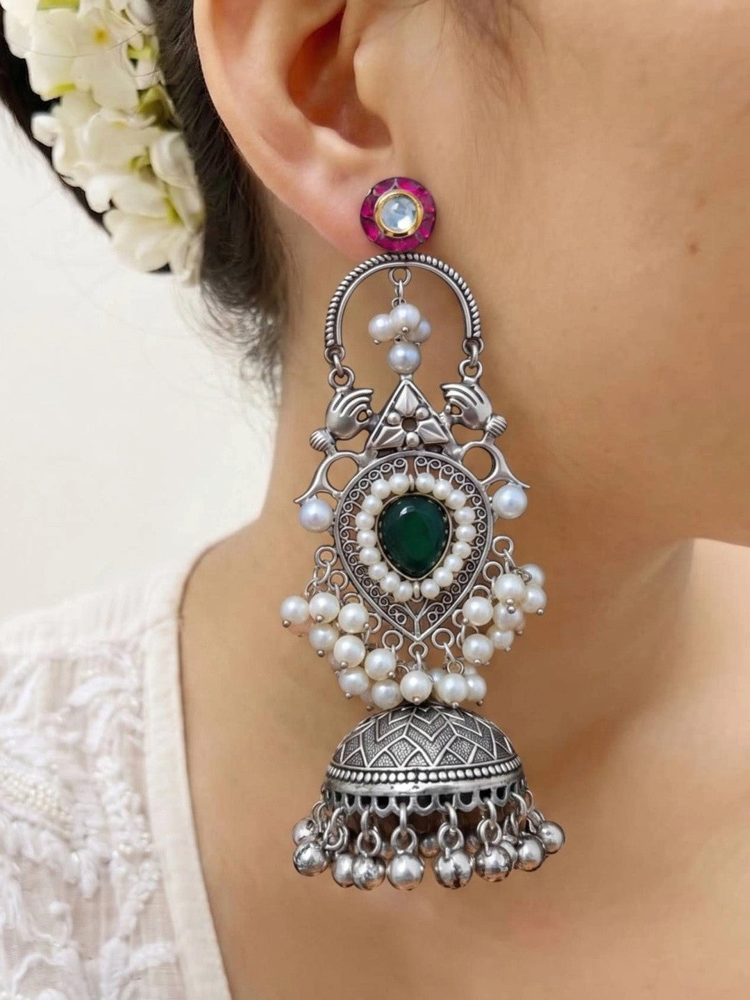 Single oxidised silver chandbali jhumka earring worn on a woman's ear showing full length from pink kundan stud to ghungroo drops