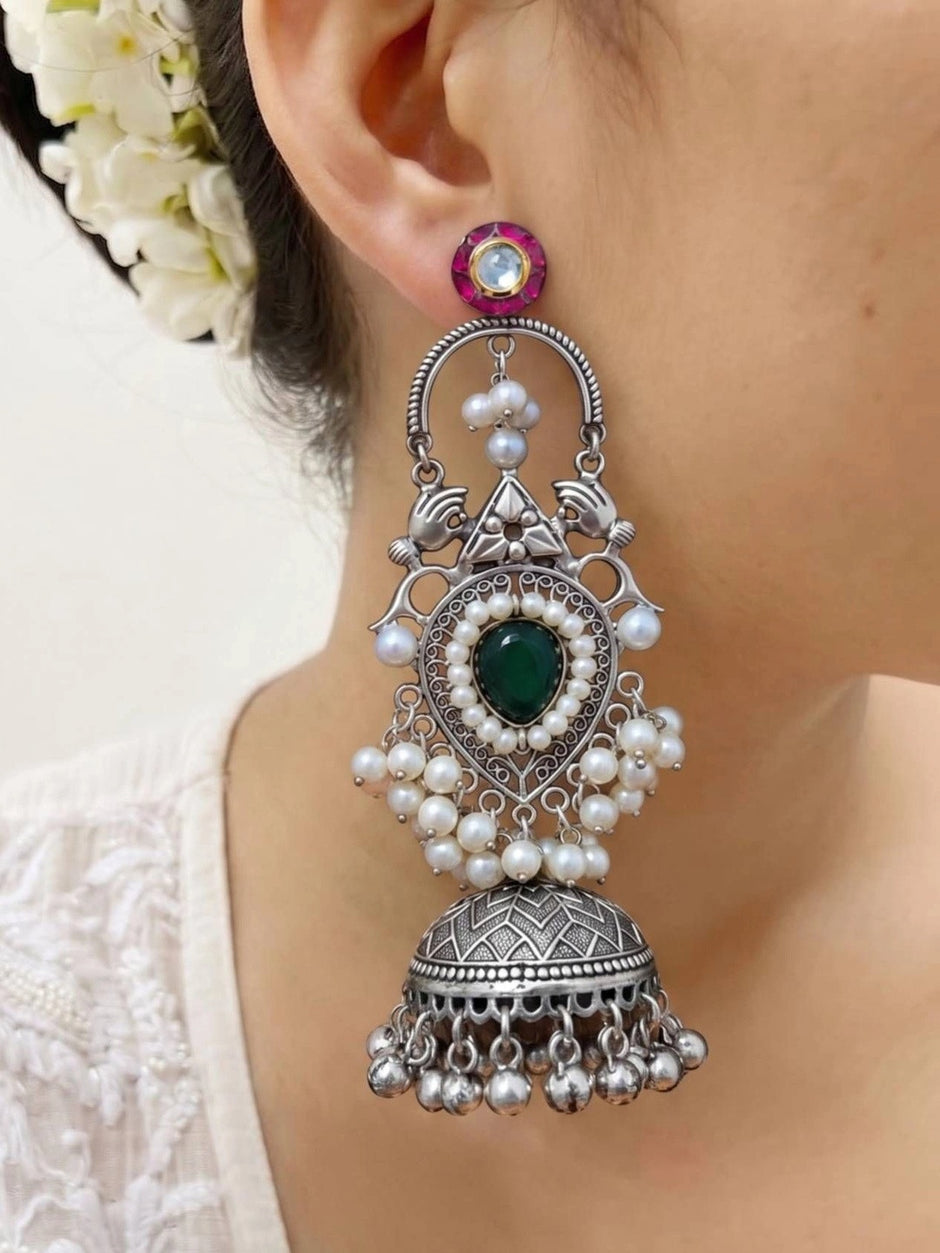 Single oxidised silver chandbali jhumka earring worn on a woman's ear showing full length from pink kundan stud to ghungroo drops