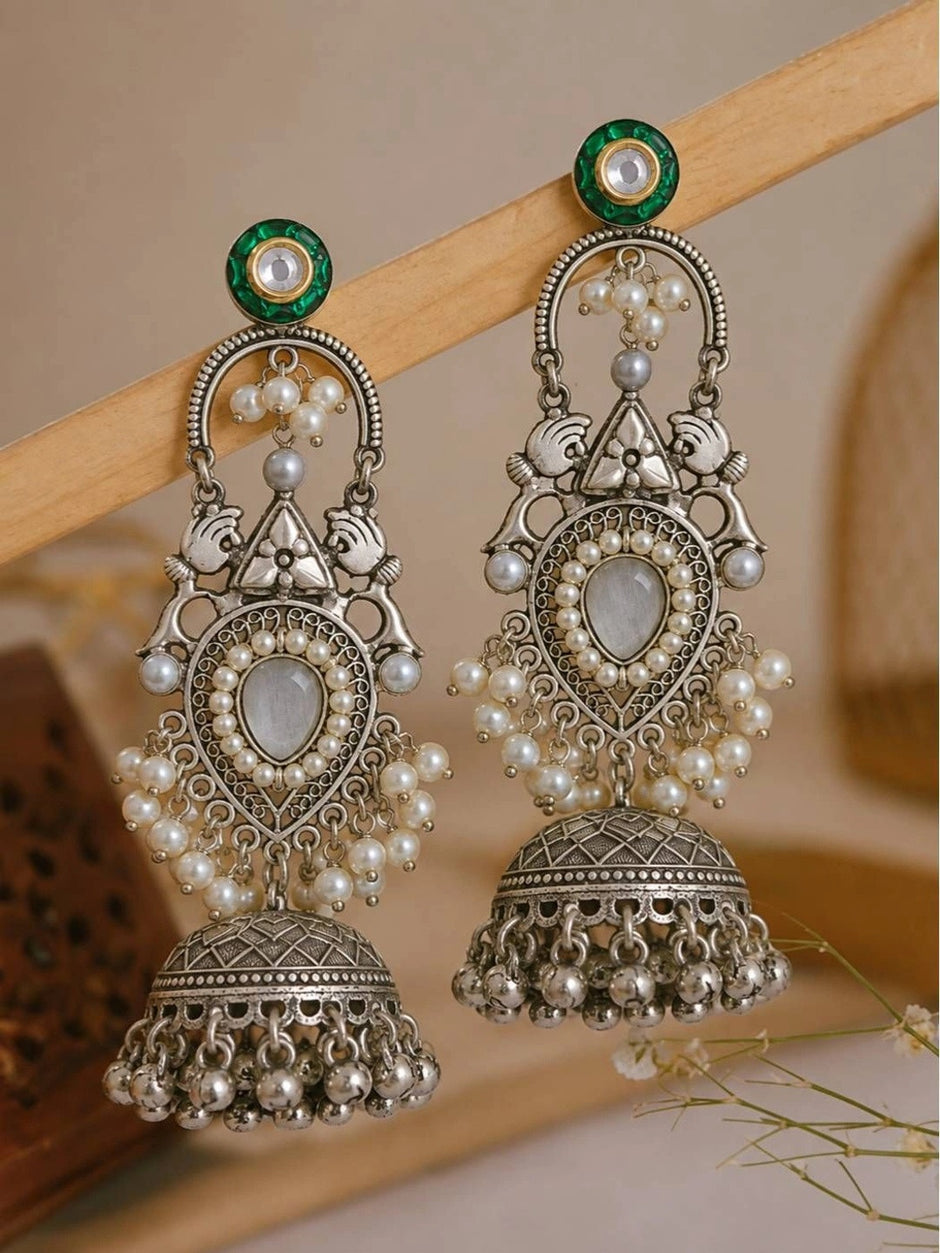 Both jhumka earrings displayed upright on a wooden jewellery stand against a neutral background