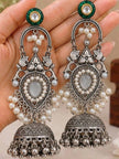 Oxidised silver jhumka earrings held in an open palm showing full length and ghungroo drops