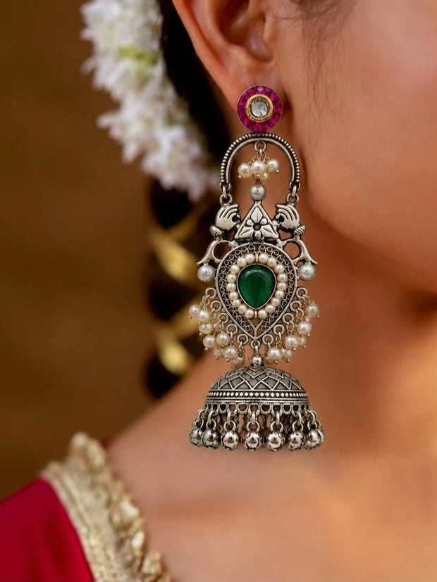 Oxidised silver teardrop jhumka earring worn by a woman in a red saree with white flowers in her hair