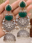 Both jhumka earrings held in open palm showing full three-tier design with dome bell and pearl drops