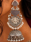 Close-up side view of one oxidised silver pearl jhumka earring worn on a woman's ear