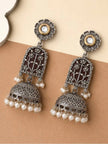 Pair of oxidised silver lotus jhumka earrings laid flat showing front and back on beige surface