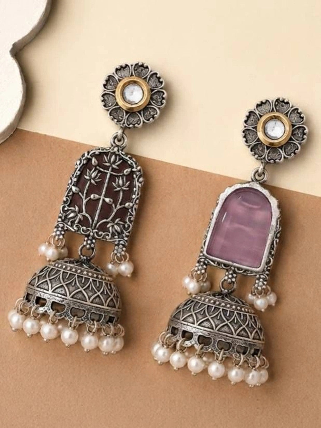 Jhumka earring pair showing one with maroon backing and one revealing pink reverse stone side