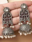 Close-up of lotus jhumka earring pair held in palm showing engraved dome and pearl drops