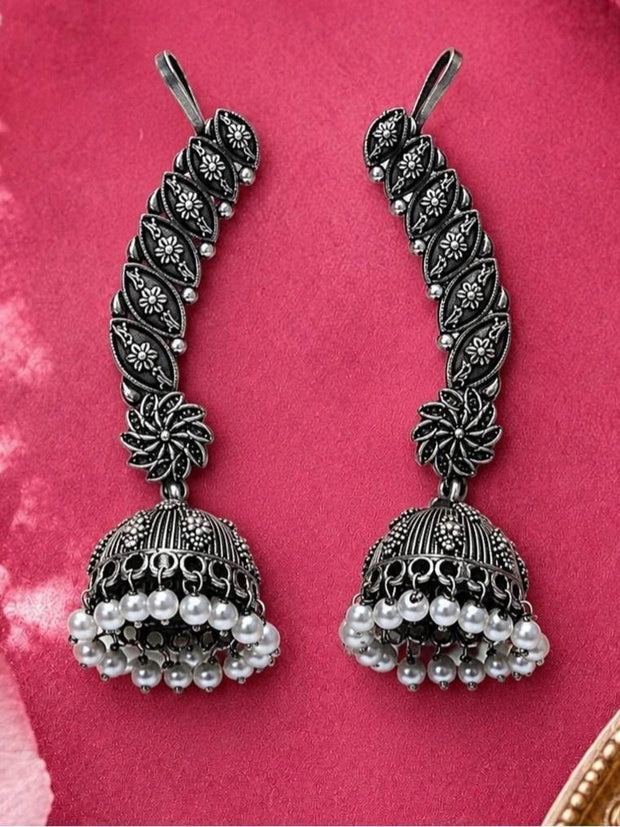 Pair of oxidised silver ear cuff jhumkas with pearl drop fringe on pink background