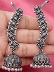 Both oxidised silver ear cuff jhumkas held in hand showing floral motif and pearl fringe