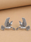 Two oxidised silver dove studs facing each other on beige background showing feather detail