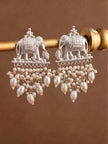 Close-up of silver elephant earrings with dense faux pearl fringe hanging from a gold-toned rod