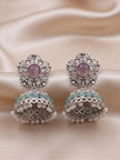 Pair of oxidised silver jhumka earrings laid flat on cream satin showing turquoise bead row and pearl fringe detail