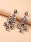 Two oxidised silver elephant jhumka earrings laid flat on beige surface showing full length and detail
