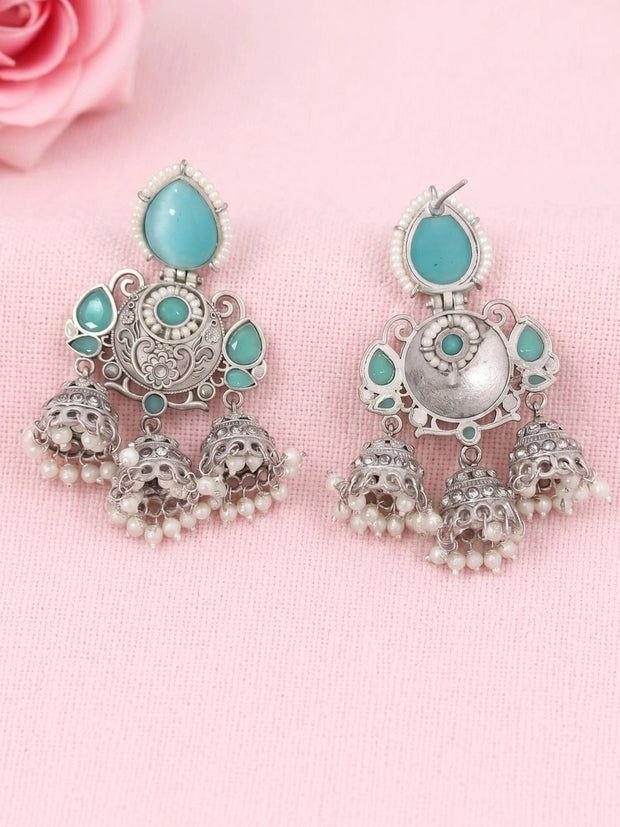 Pair of oxidised silver jhumka earrings front and back view on pink fabric