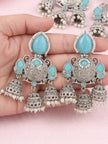 Hand holding a pair of oxidised silver triple jhumka earrings showing scale and detail