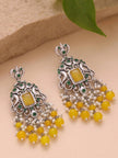Front view of pair of oxidised silver chandbali earrings with yellow bead and pearl tassels