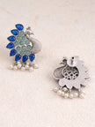Front and back view of oxidised silver peacock stud earrings on cream fabric background