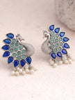 Close-up side-by-side view of peacock stud earrings showing textured silver body and stone detail