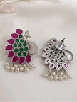 Front and back view of a single peacock stud earring on white fabric showing push-back fastening and stone setting
