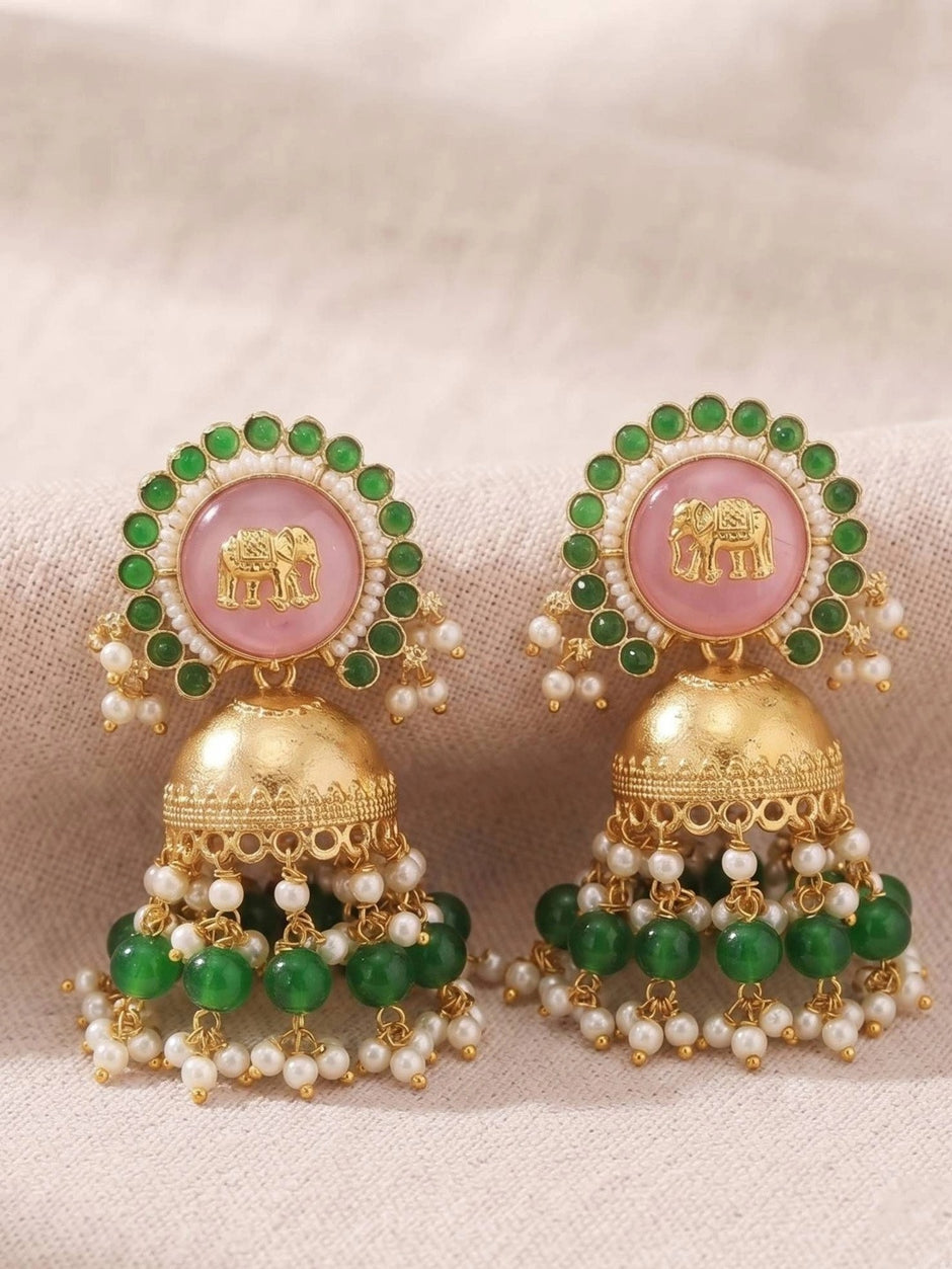 Pair of elephant jhumkas flat lay on cream fabric showing full green bead and pearl cascade