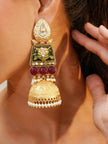 Gold-plated Meenakari kundan jhumka worn on a woman's ear, showing green enamel panel, red beads and pearl-fringed dome