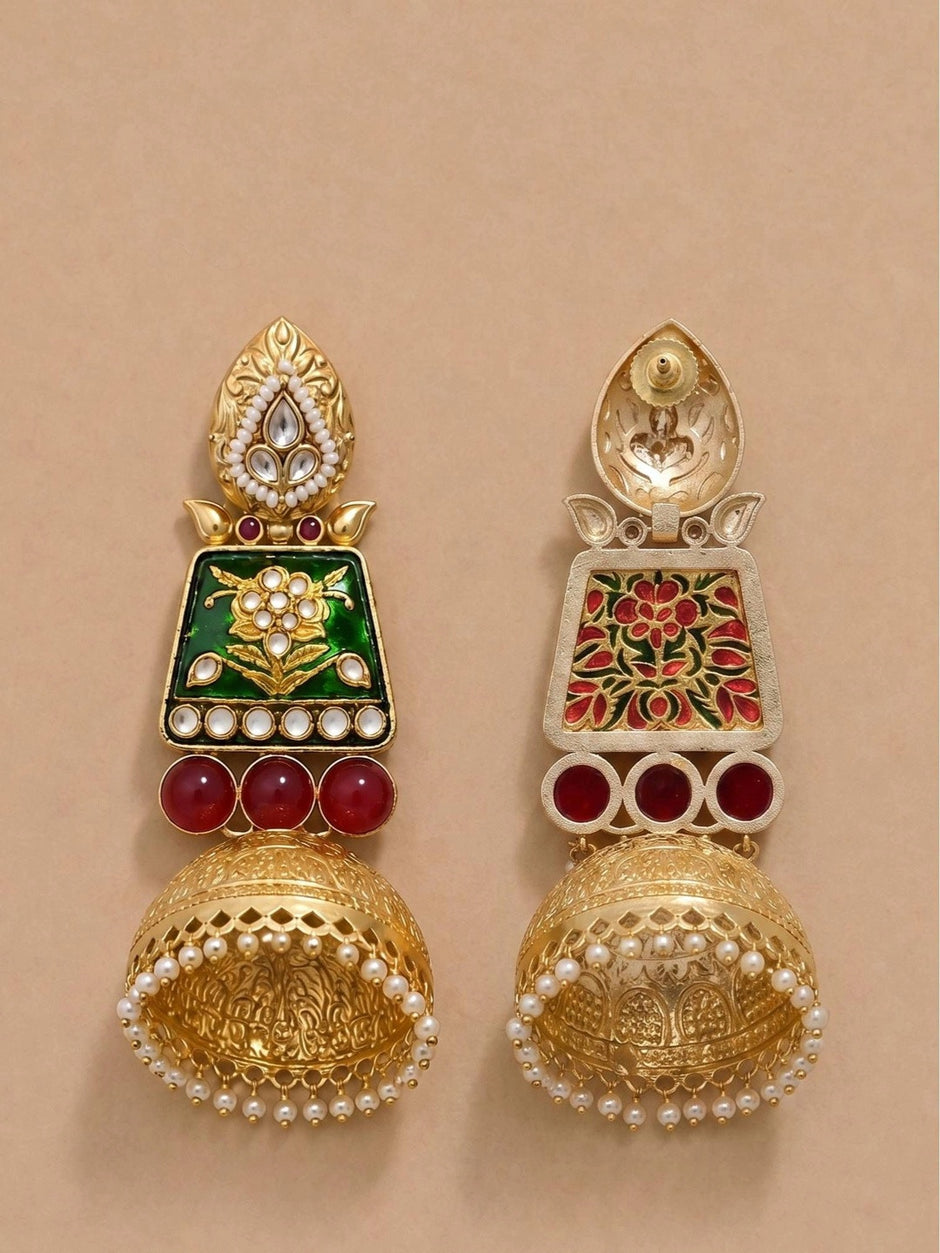 Front and back view of one jhumka earring on beige surface, back reveals red and green meenakari reverse detailing