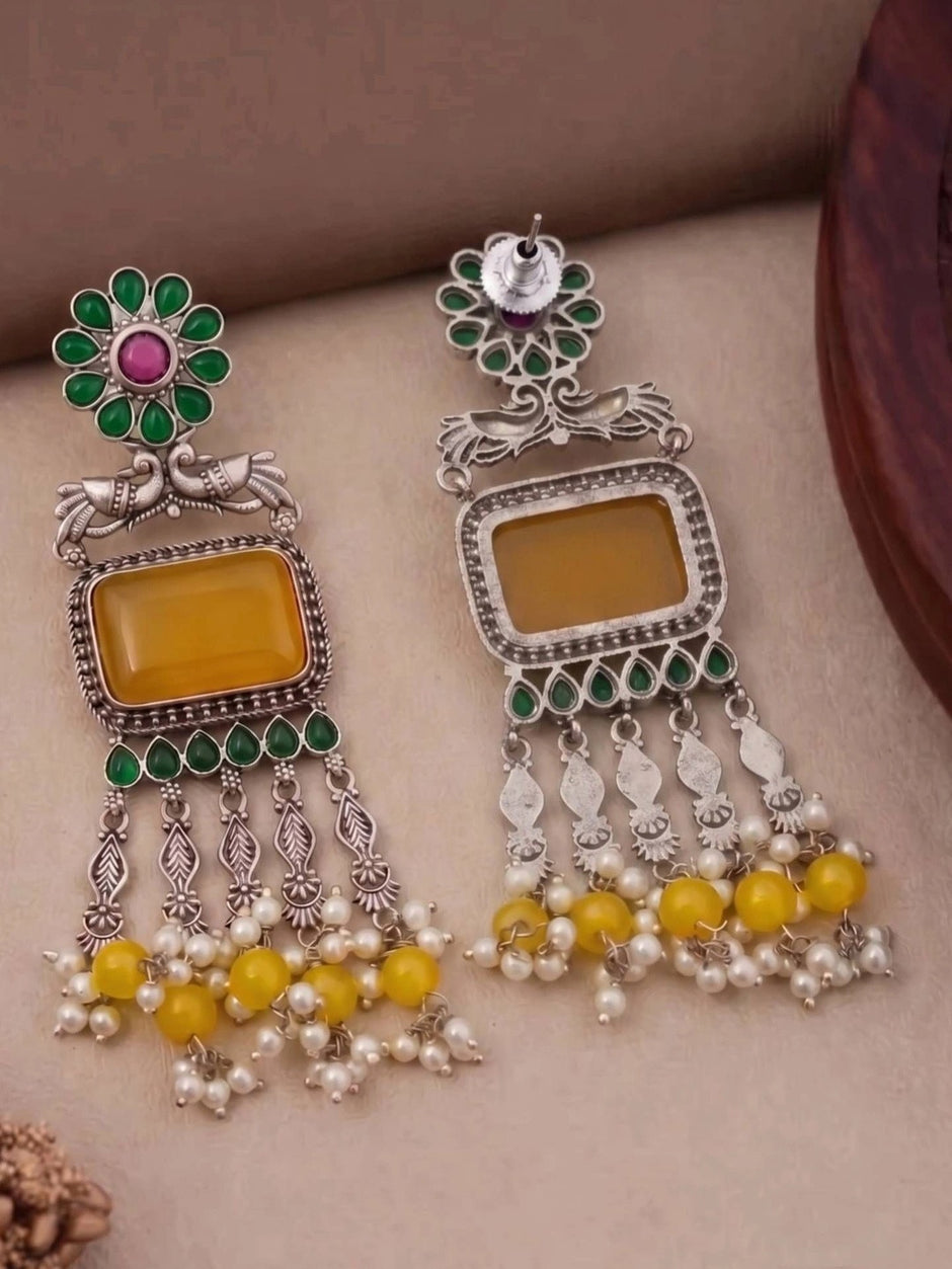 Front and reverse side of oxidised silver chandbali earrings showing push-back stud and plain back of yellow stone frame