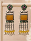 Two oxidised silver chandbali earrings standing upright on display rack showing full length and cascading pearl and yellow bead drops