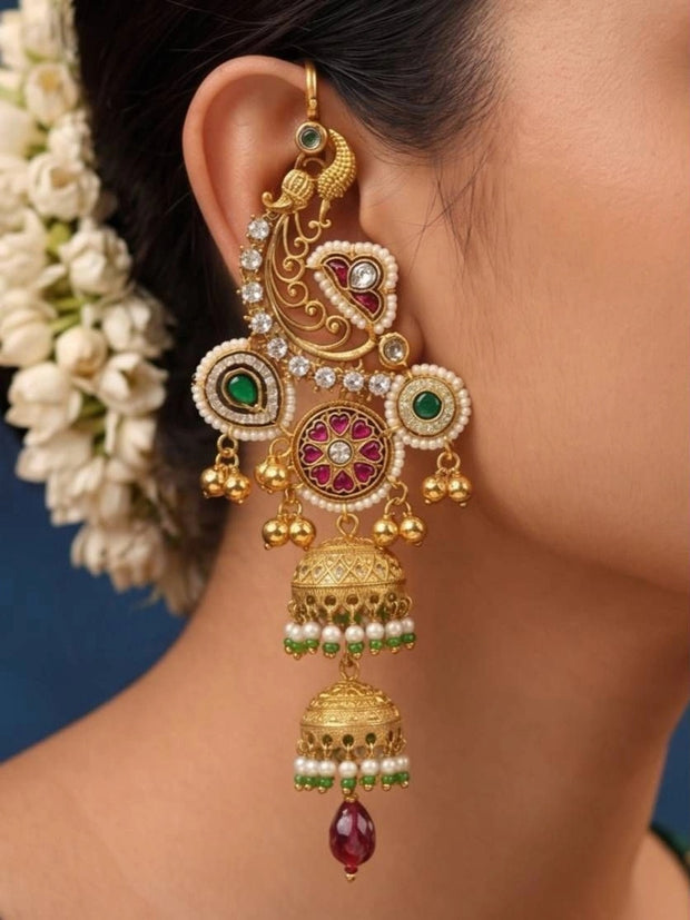 Gold-plated peacock chandbali jhumka earring worn on a woman's ear with jasmine hair flowers