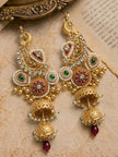 Gold peacock chandbali double jhumka earring worn on a womans ear with white flower hair accessory