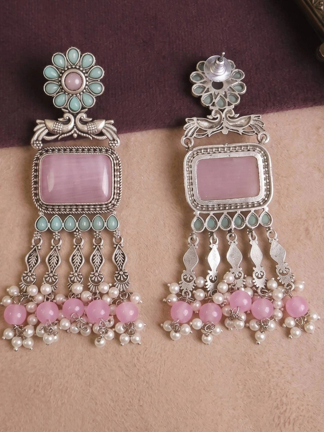 Front and reverse side of oxidised silver chandbali earrings showing stud back and engraved tassel detailing on a fabric surface